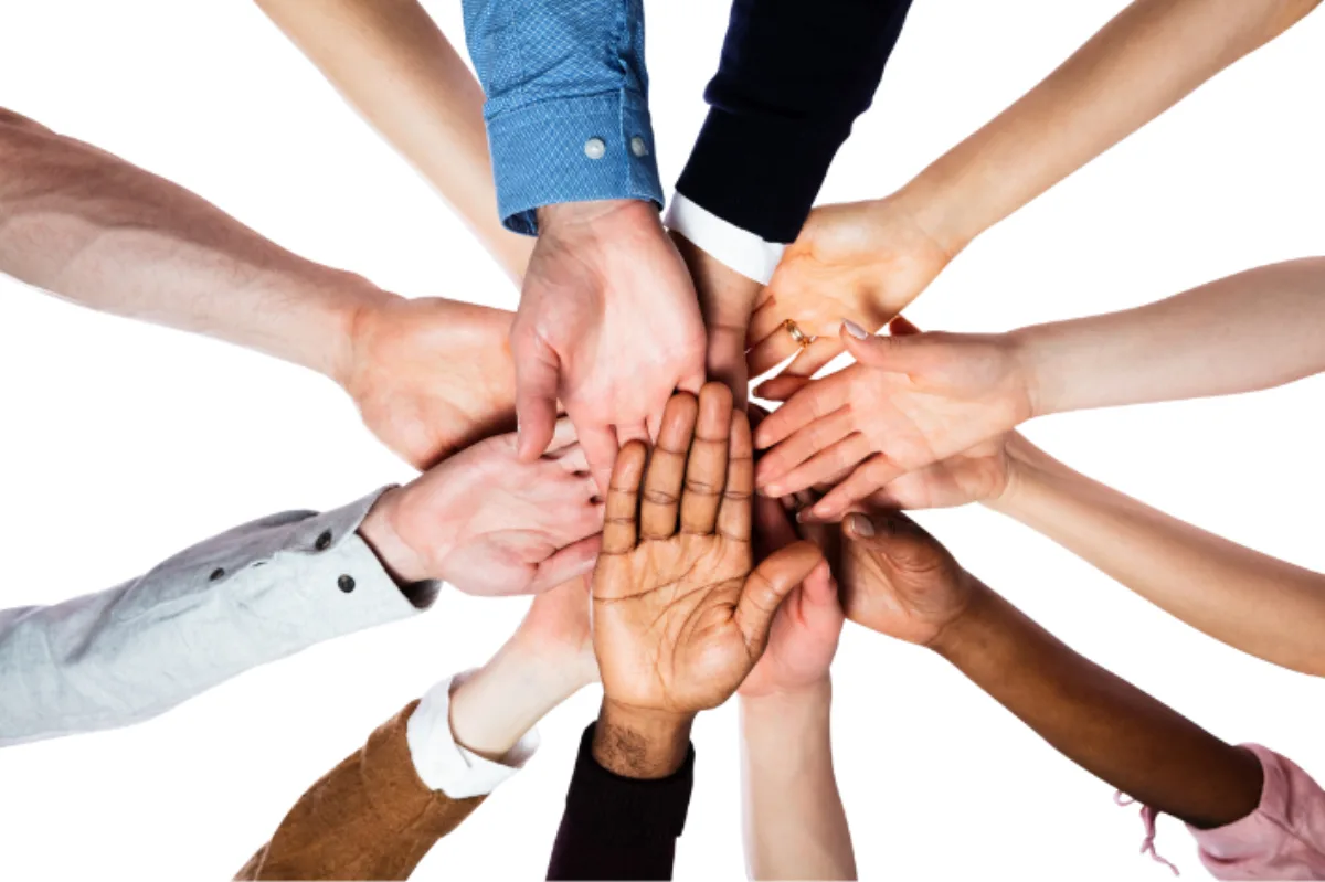Viele Hände, die sich in der Mitte treffen – Symbolbild für Klassengemeinschaft und Teambuilding