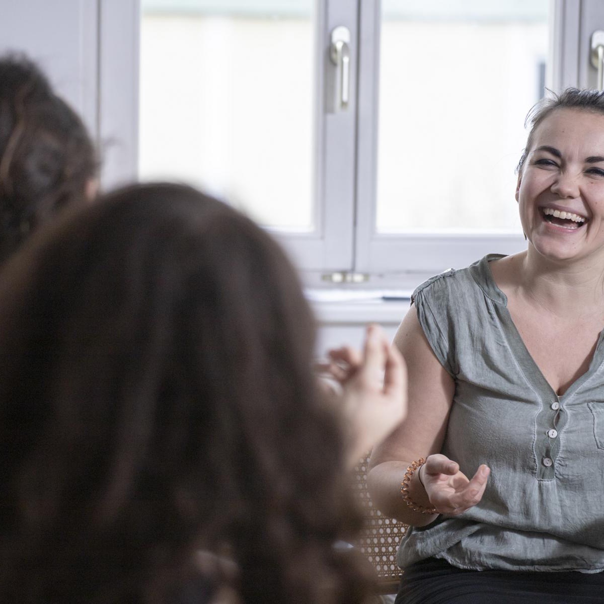 Hannah Schrems lacht gemeinsam mit einem Team in einem Workshop